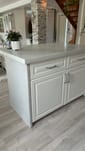 Kitchen island with cast white concrete worktop and plastered side panels