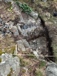 Urgrävd grundyta för jordkällaren mellan berg och terräng.
