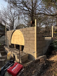 Block walls built around a round plywood door template.