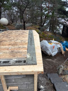 Gjuten kantbalk på jordkällarens takform med uppstickande armering.