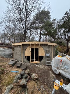 Front of root cellar with round opening and completed roof form.